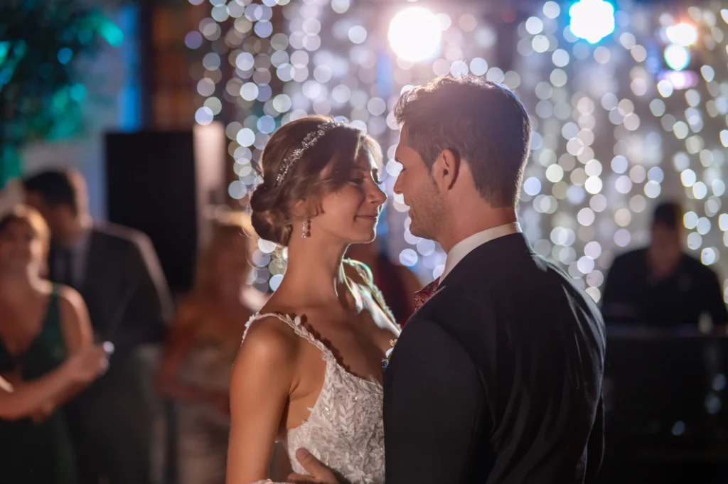 Novios bailando en el banquete de boda rodeados de invitados