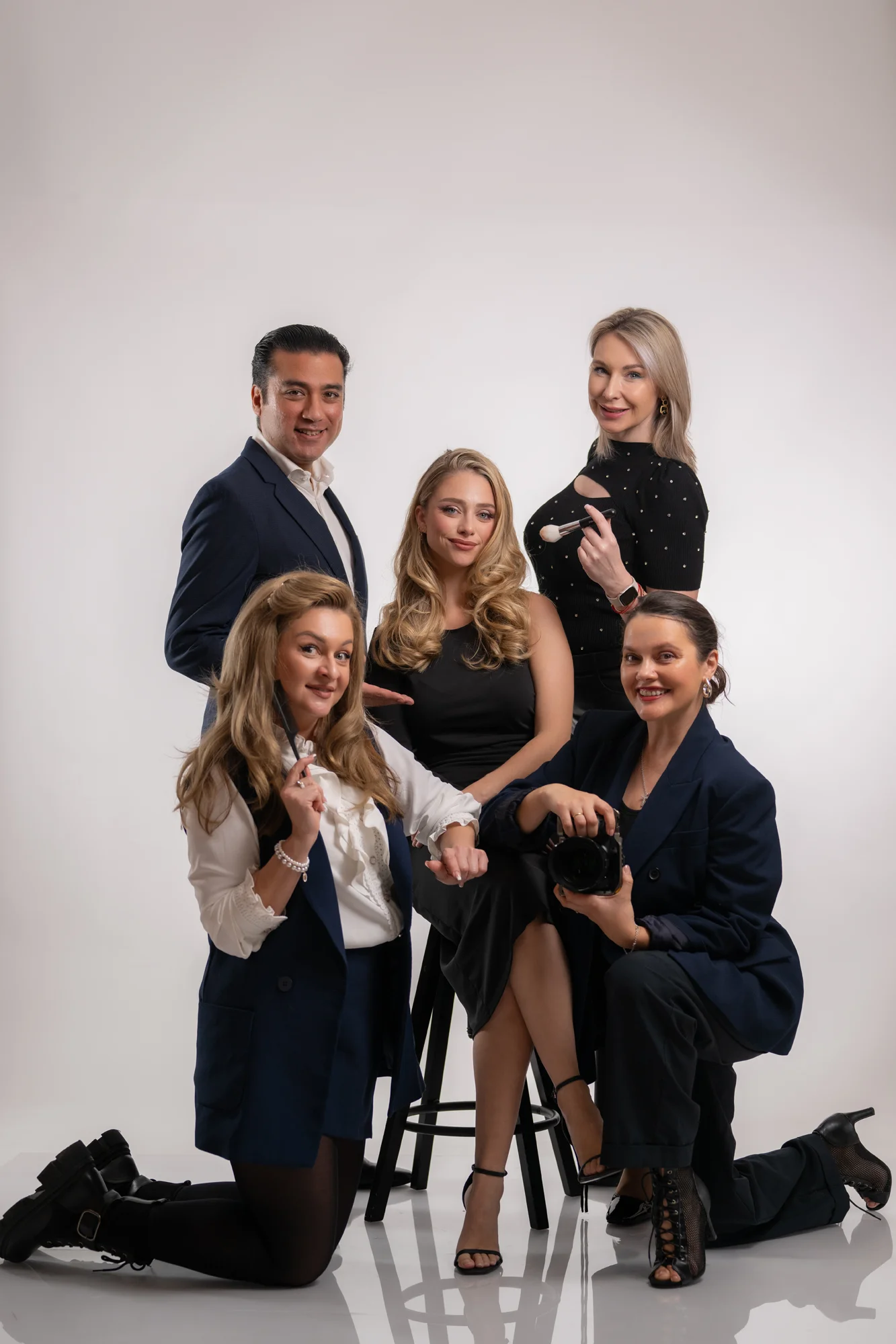 Equipo de fotografía, maquillaje y estilismo posando con la modelo en el estudio