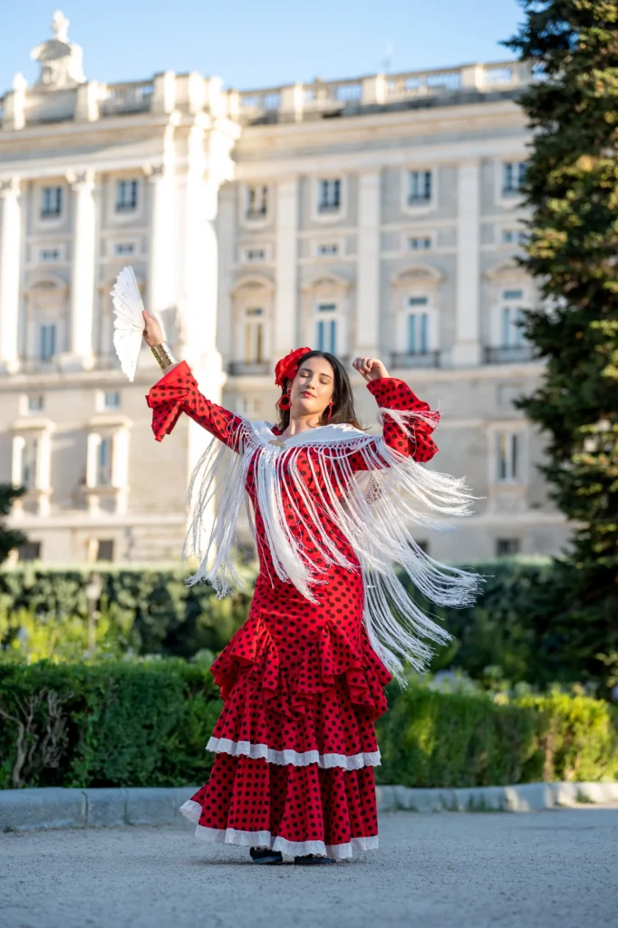 Mujer con traje de flamenca rojo y mantón bailando frente al Palacio Real de Madrid