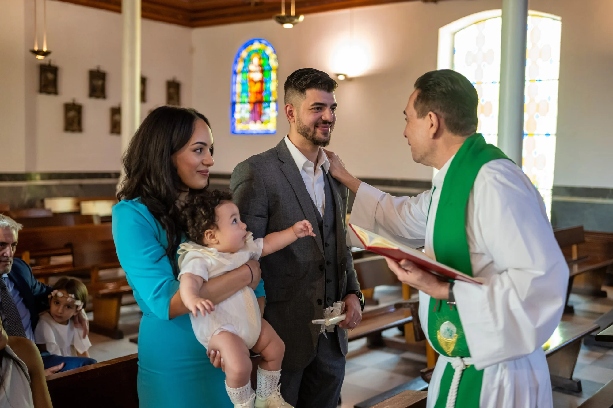Padres con su bebé en brazos junto al sacerdote tras el bautizo en la iglesia