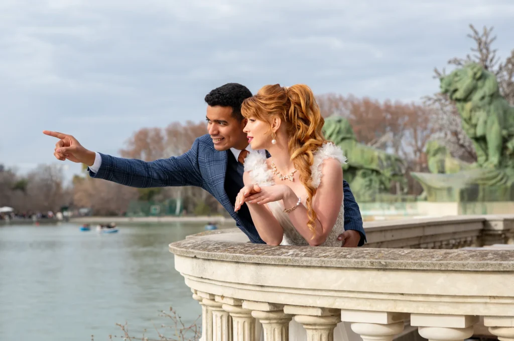 Chico señalando el horizonte a su pareja pelirroja junto al estanque del Retiro