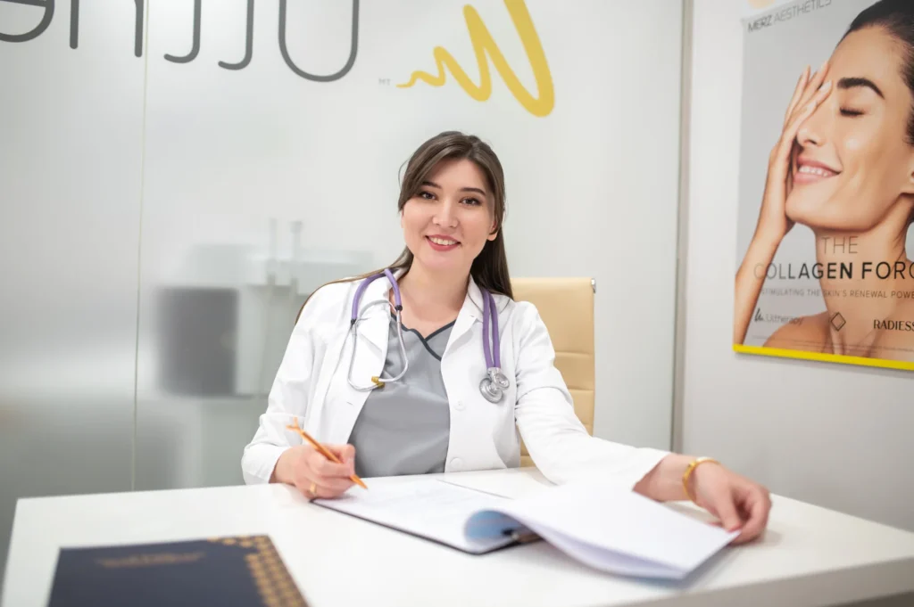 Doctora con bata blanca sonriendo en su consulta en un retrato corporativo