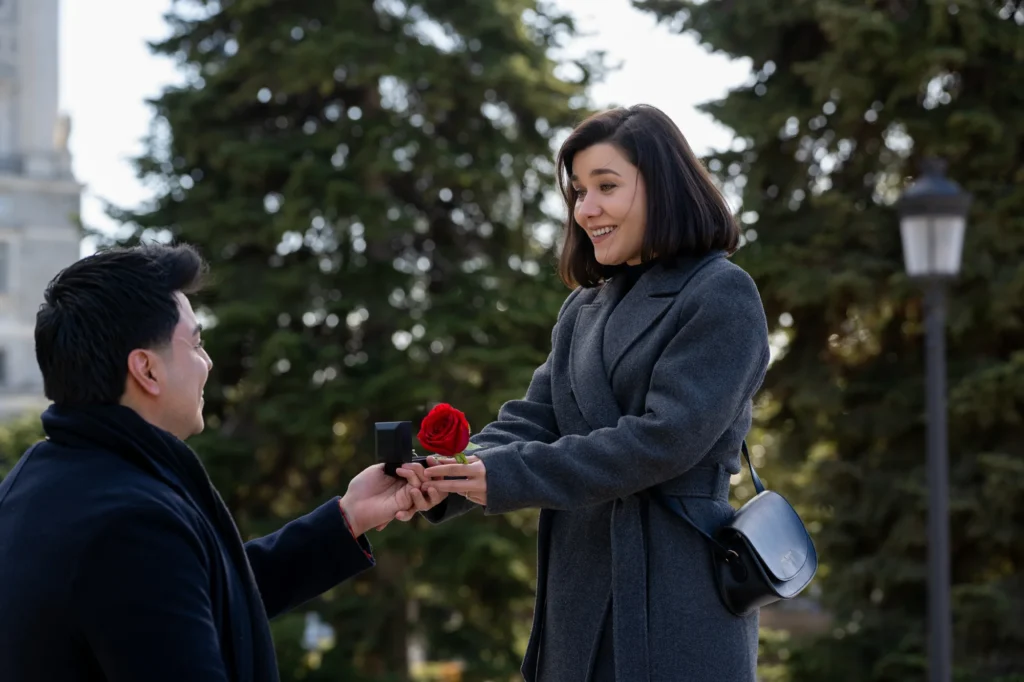 Hombre ofreciendo una rosa y el anillo a su novia en un jardín de Madrid