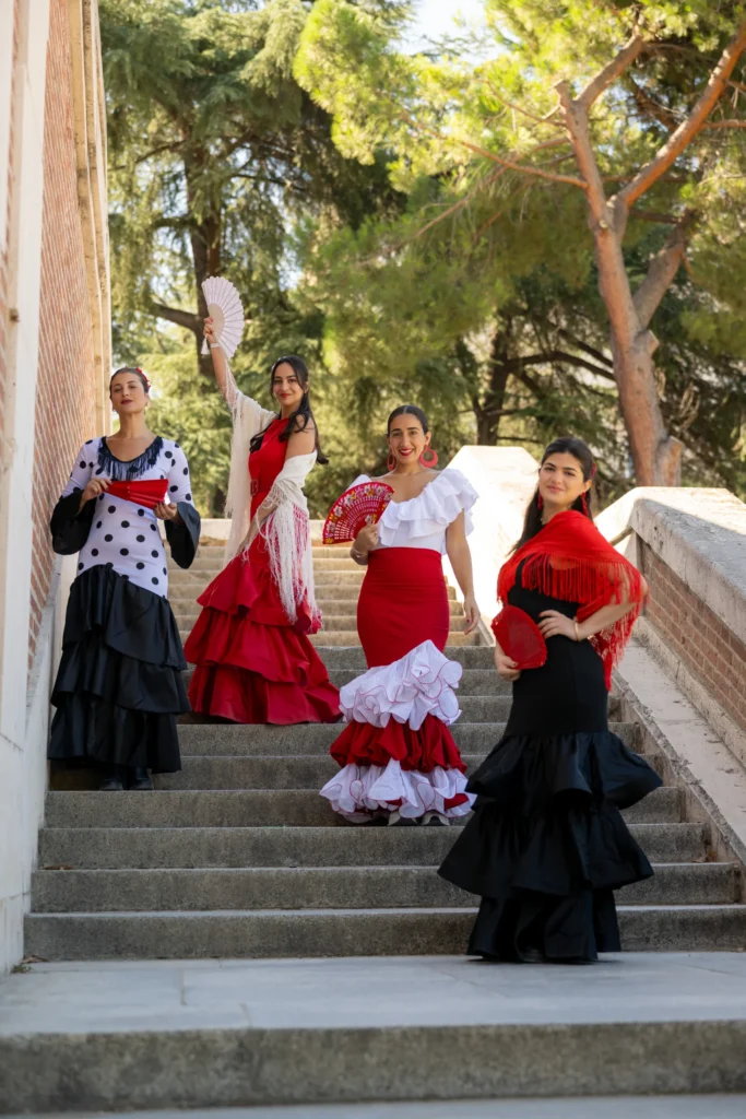 Grupo de cuatro mujeres vestidas de flamenca posando en unas escaleras de un parque de Madrid