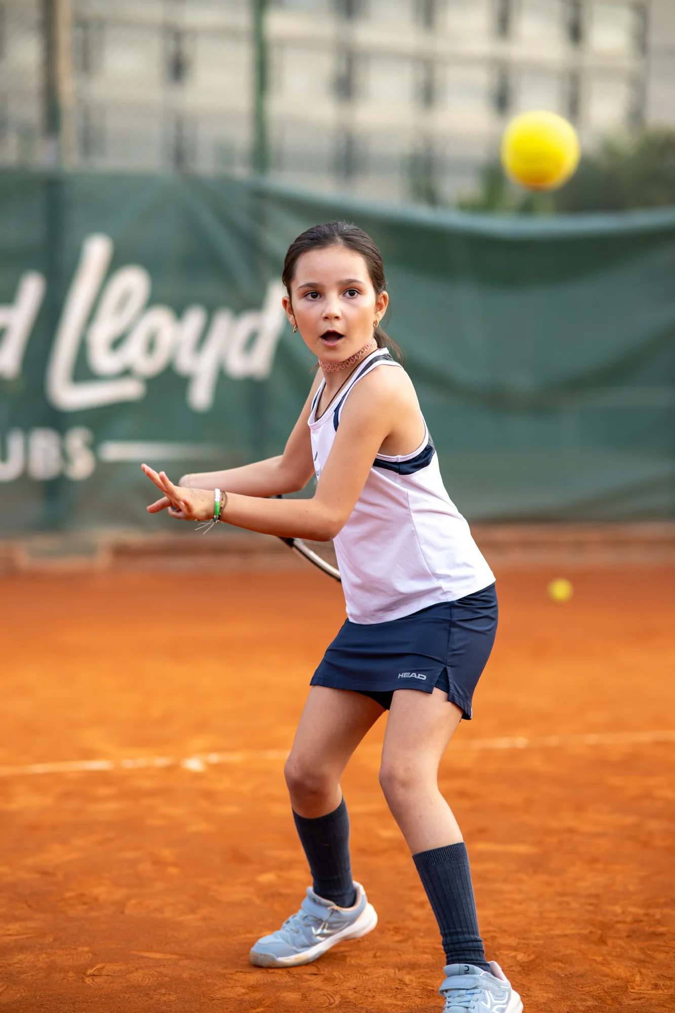 Joven tenista preparando un golpe en la pista de tierra batida del club David Lloyd