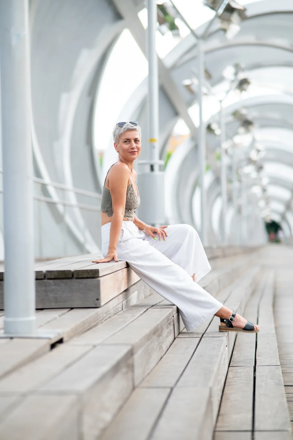 Modelo con pantalón blanco sentada en los bancos de madera del Puente de Arganzuela