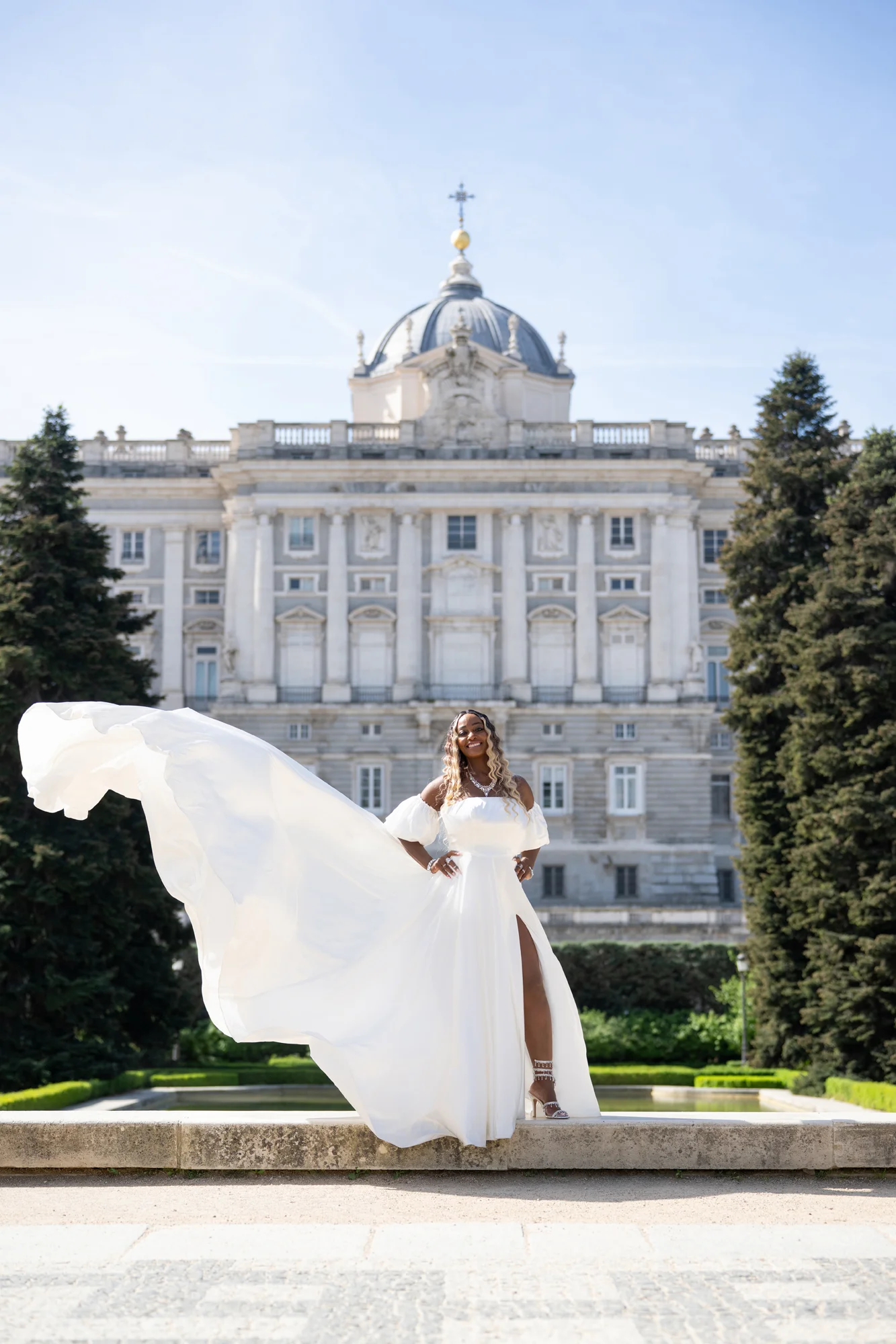 Mujer con vestido blanco al viento en los Jardines de Sabatini frente al Palacio Real