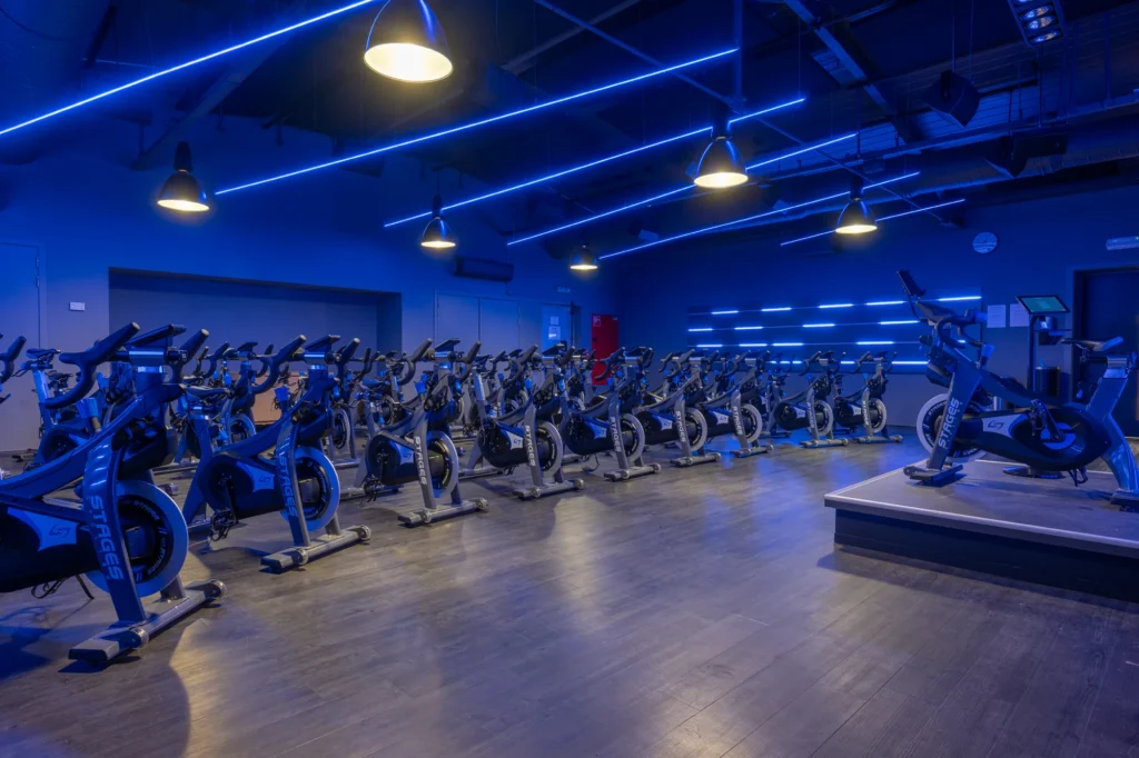 Sala de ciclo indoor con bicicletas estáticas e iluminación azul