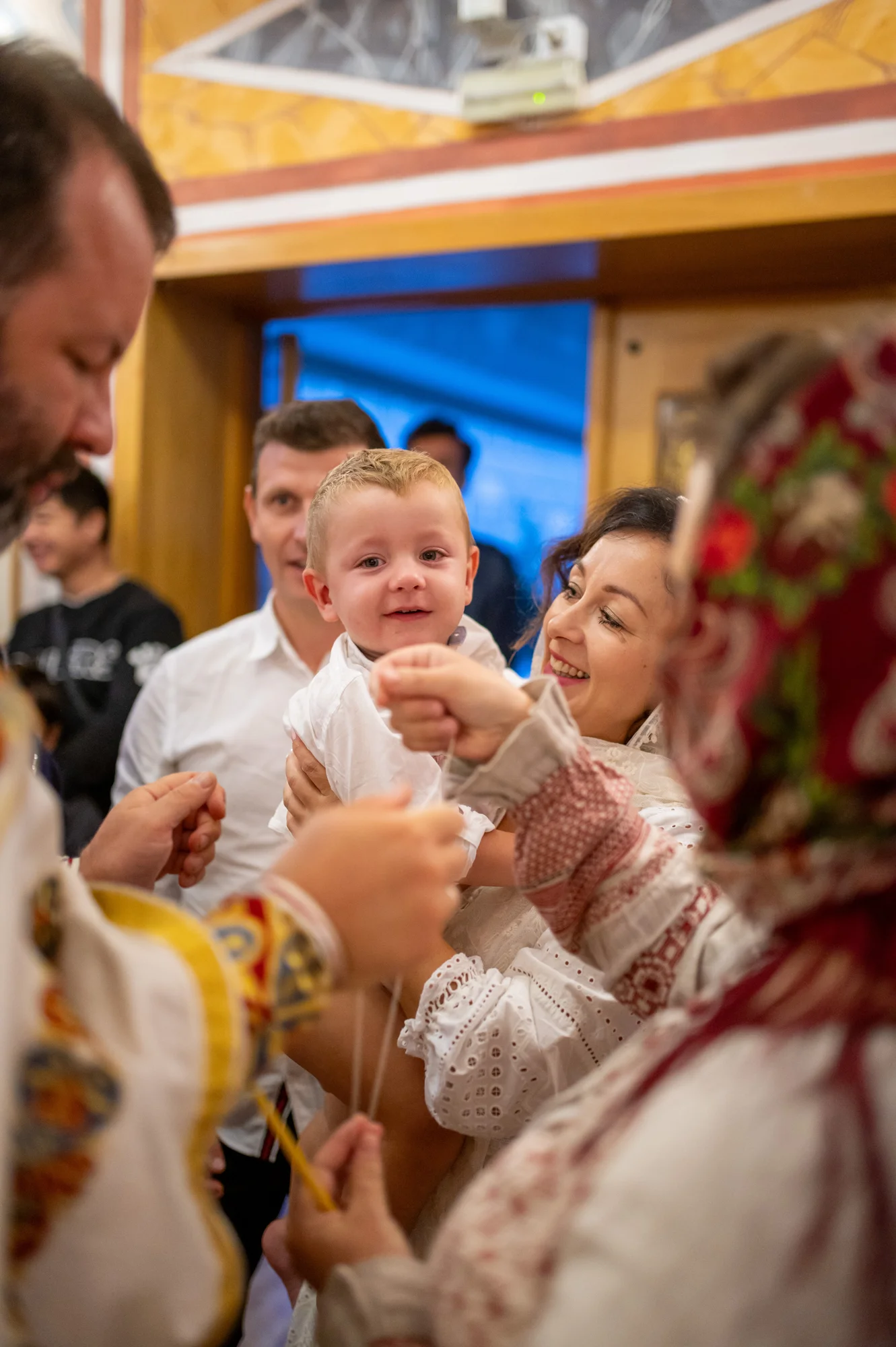 Familia con trajes tradicionales celebrando el bautizo del bebé en una iglesia ortodoxa
