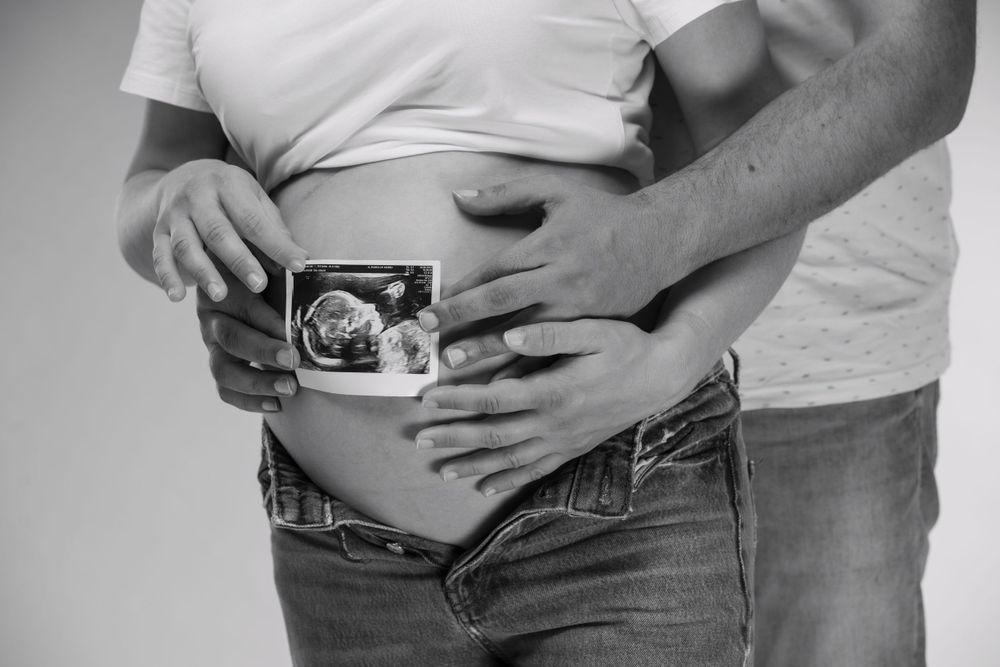 Pareja sujetando la ecografía sobre la barriga