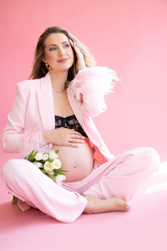 Embarazada con traje rosa sobre fondo rosa