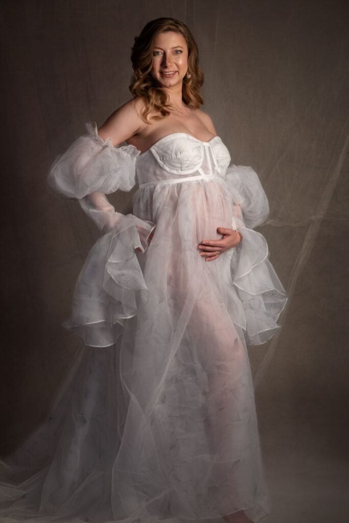 Embarazada con vestido blanco con flores y volumen