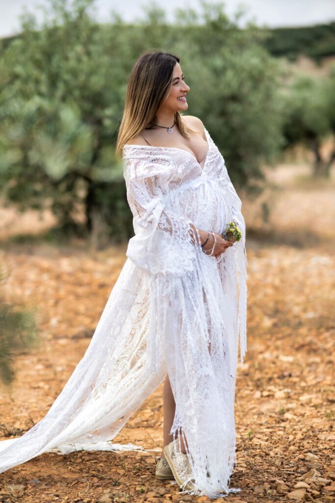 Embarazada con vestido blanco largo en una sesión en exterior